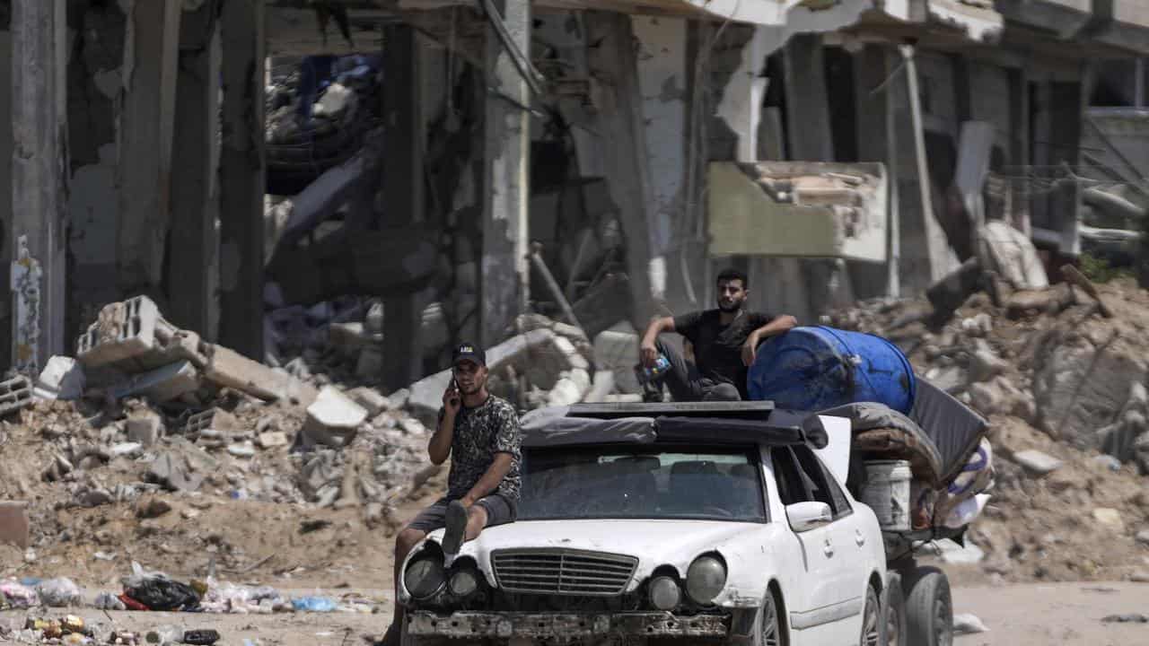 Two Palestinians transport their belongings out of the war zone.