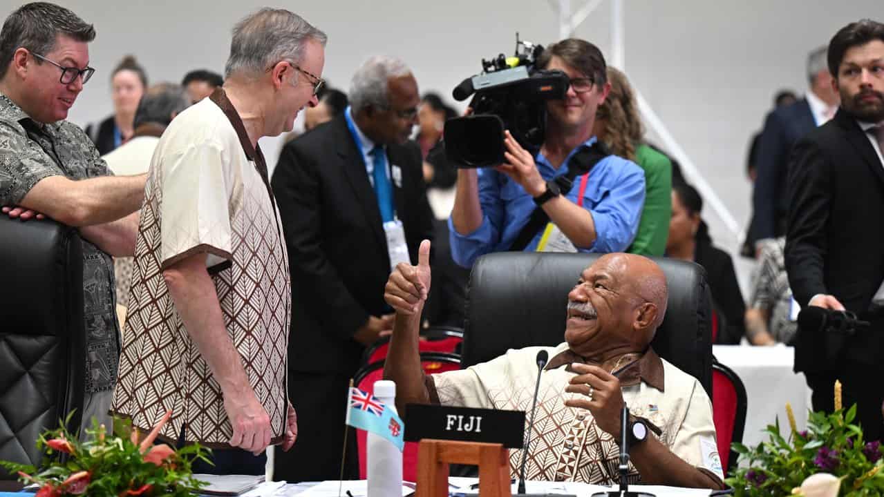 Mr Rabuka gives Mr Albanese a thumbs up after the shoulder rub.