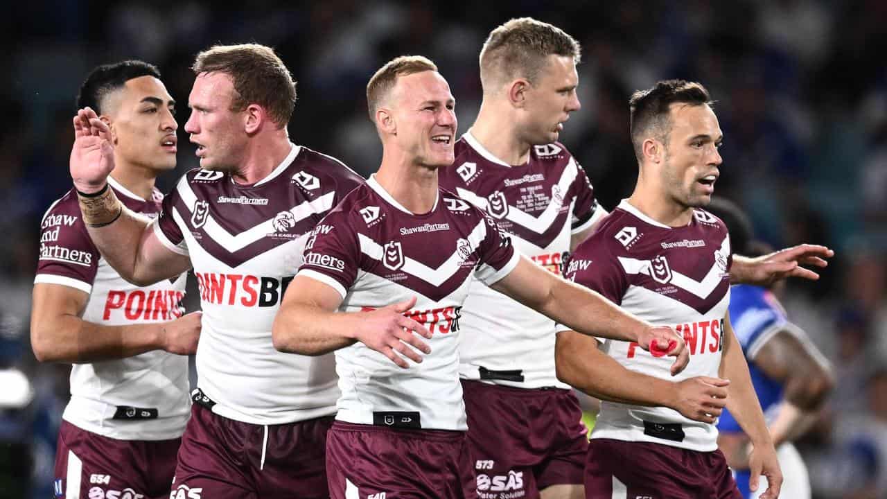 Manly players celebrate a try.