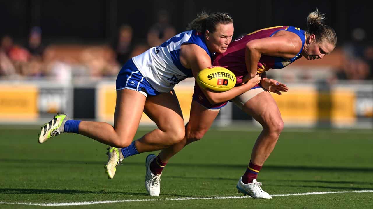 Kate Lutkins (right) of the Lions is tackled by Vikki Wall (left).