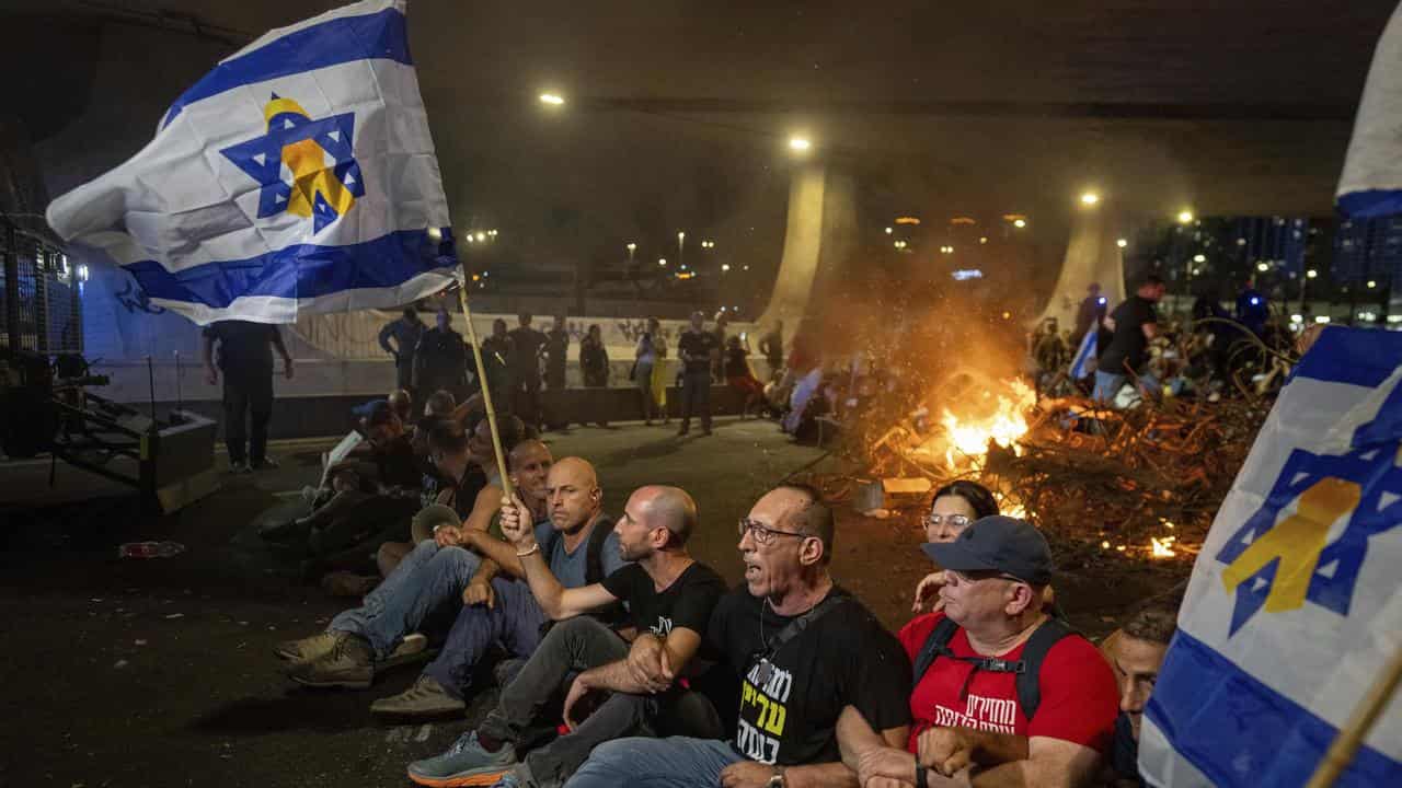 People block a road as they protest in Tel Aviv, Israel