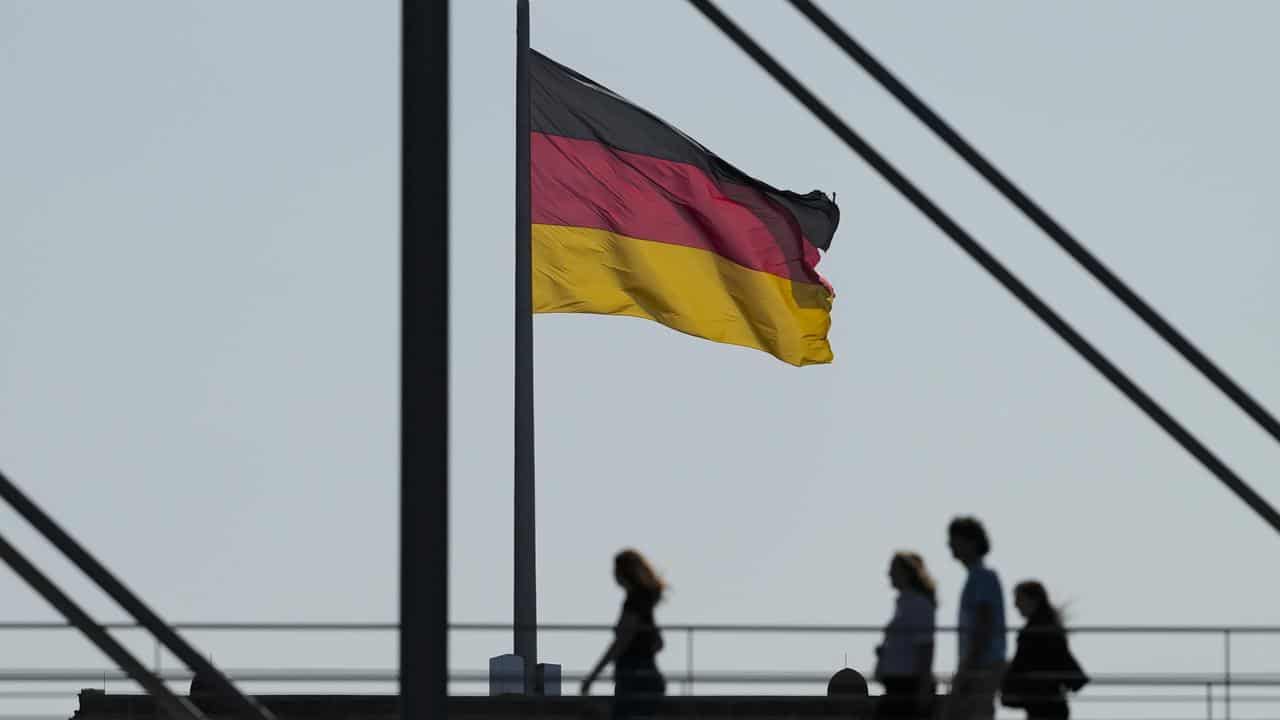 A German national flag between parliament buildings in Berlin, Germany