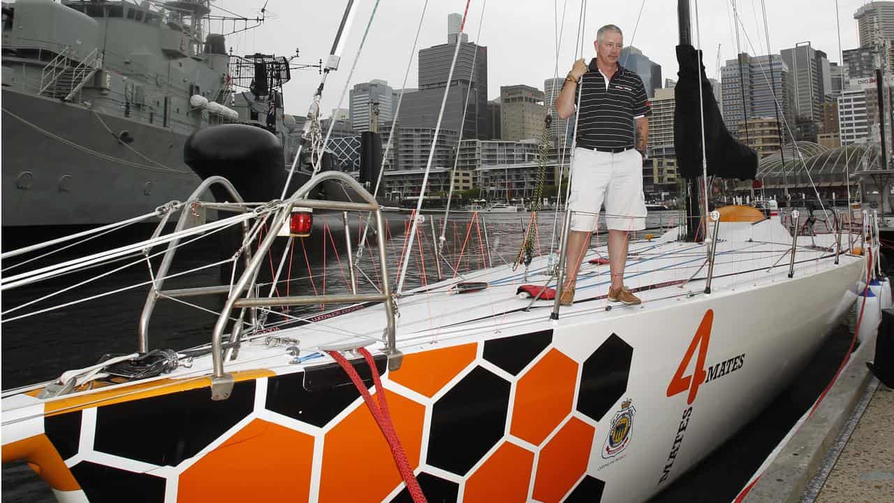 A man stands on the deck of a yacht.