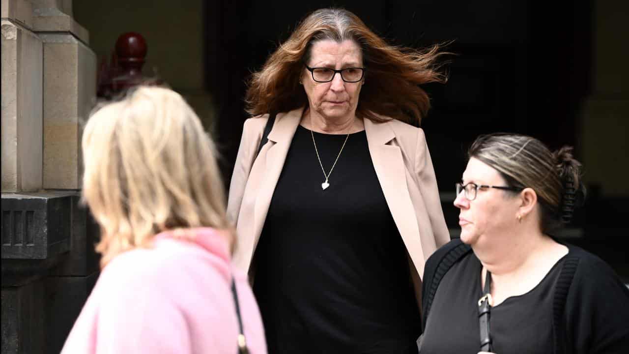 Lorraine Harris (centre) leaves court