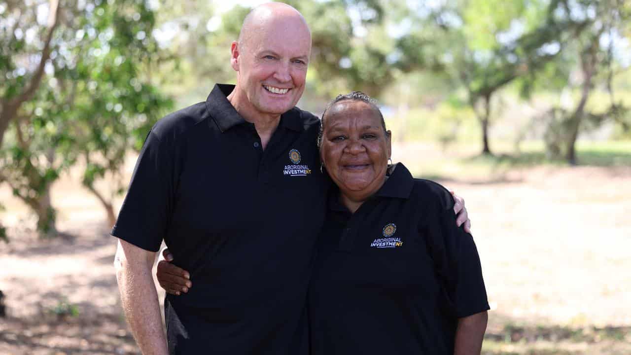 Two people with their arms around each other in a park.