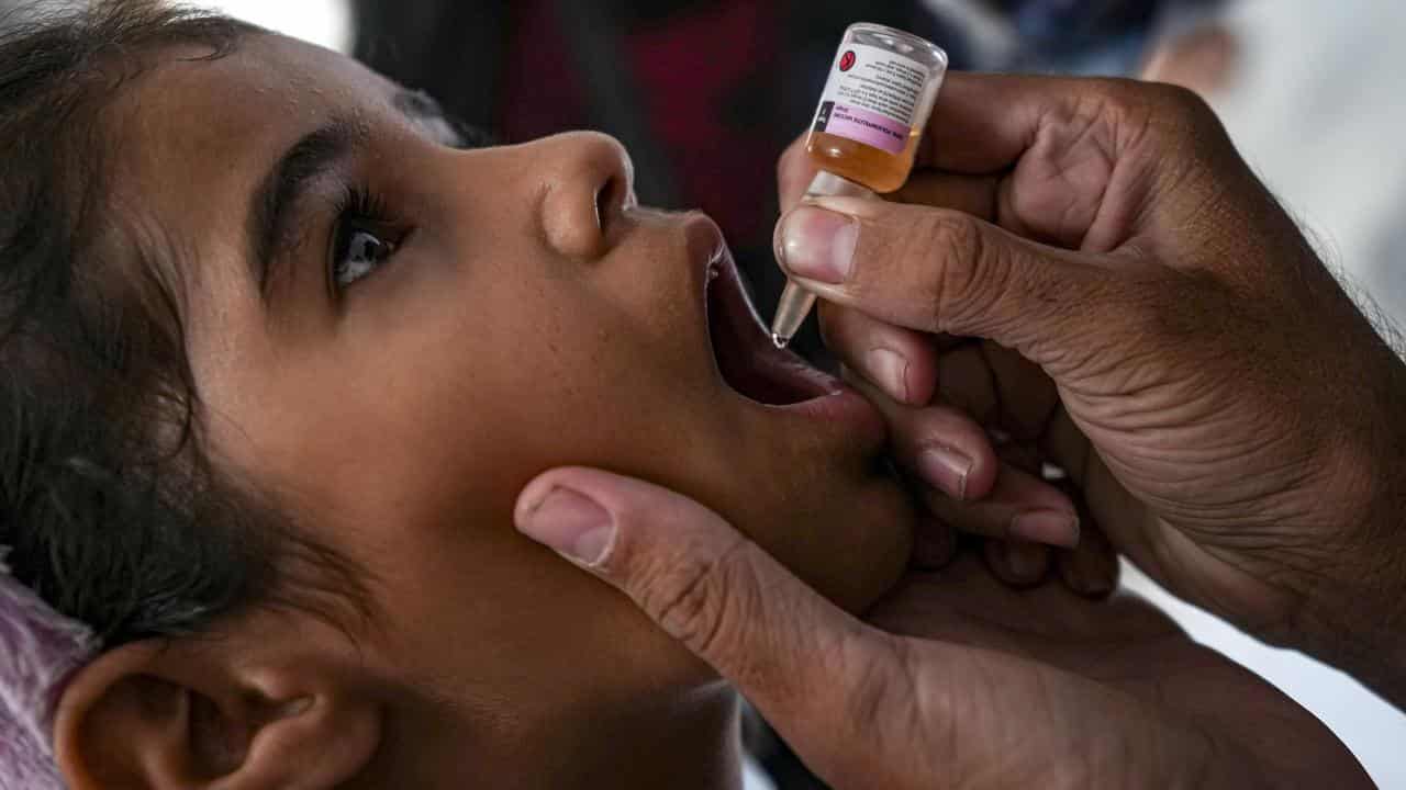 A child is given an oral polio vaccine.