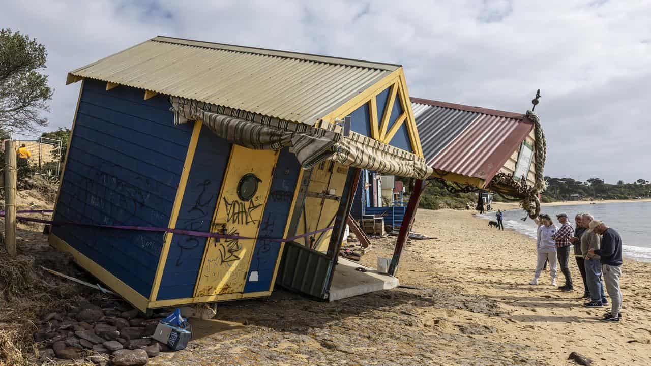 People inspect damaged bathing boxes.