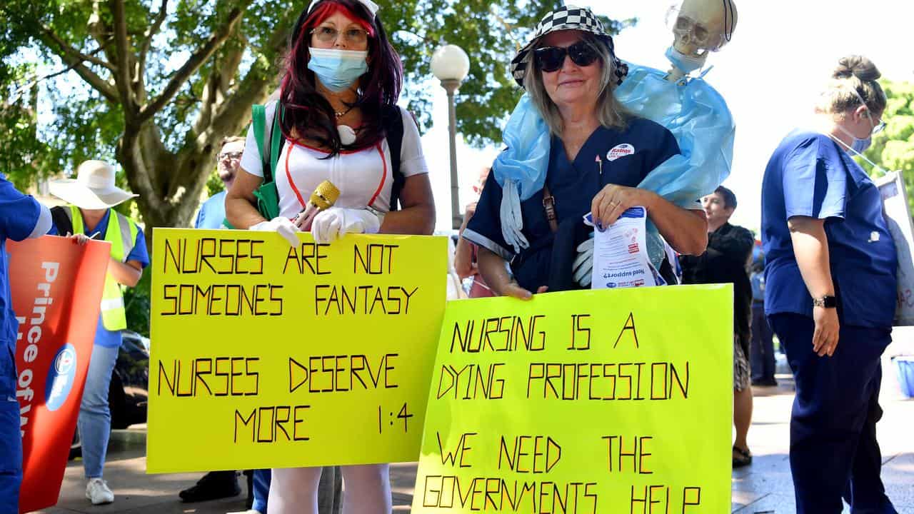 Nurses hold placards during a rally.