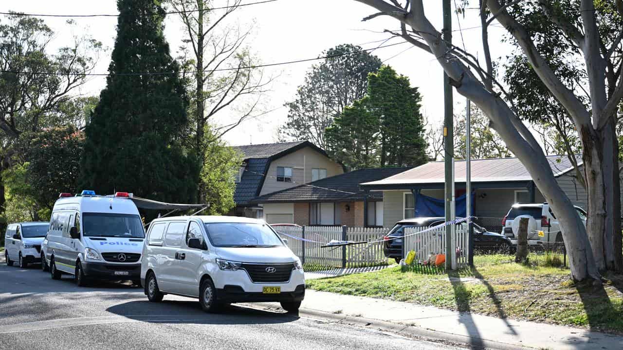 Tributes laid against a fence at the home where two boys died.