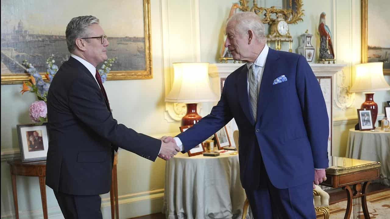 King Charles III shakes hands with Keir Starmer at Buckingham Palace