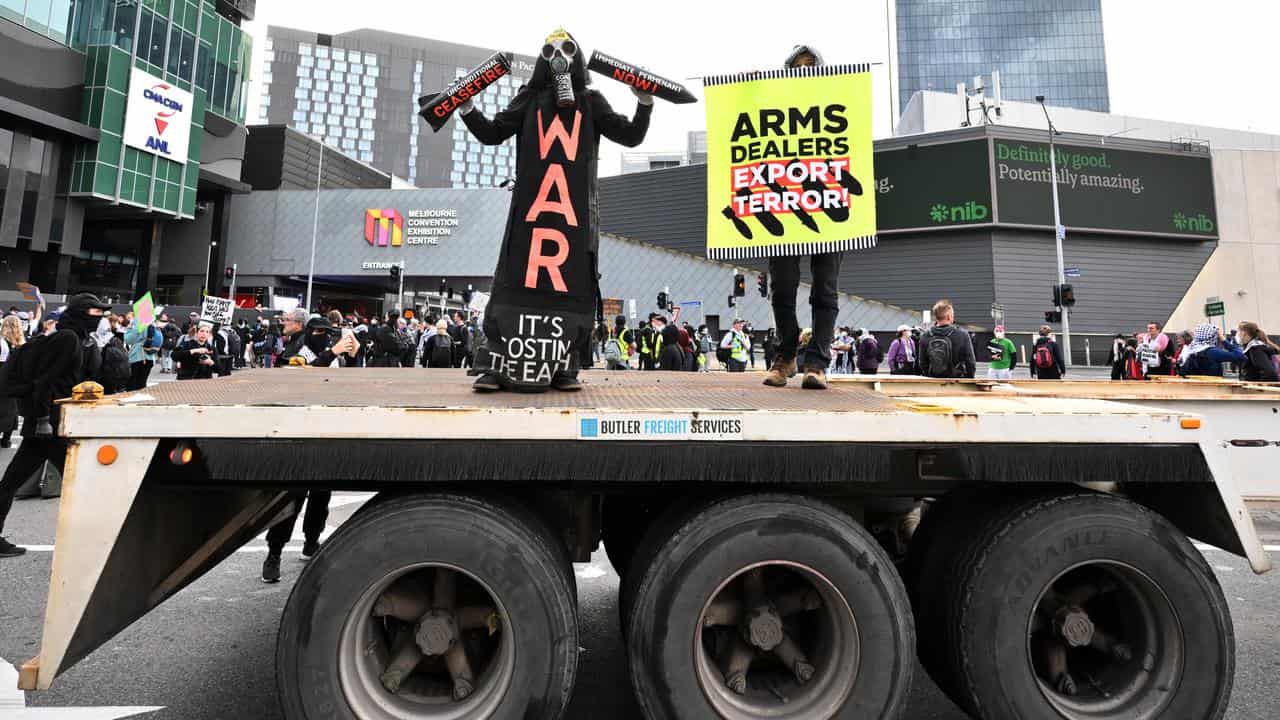 Protesters rally outside the LandForces expo