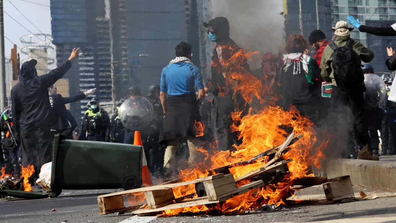 A wooden pallet set on fire during a protest outside the expo.