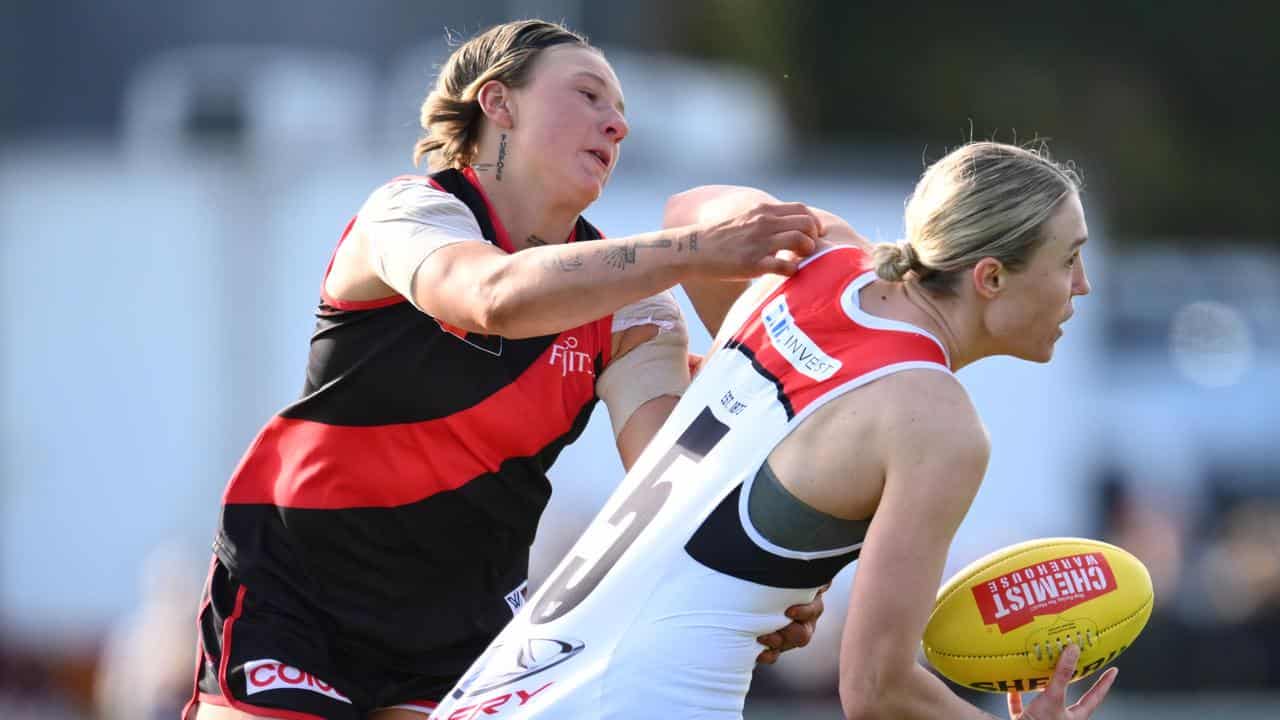 Paige Scott of Essendon (left) tackles Darcy Guttridge of St Kilda.