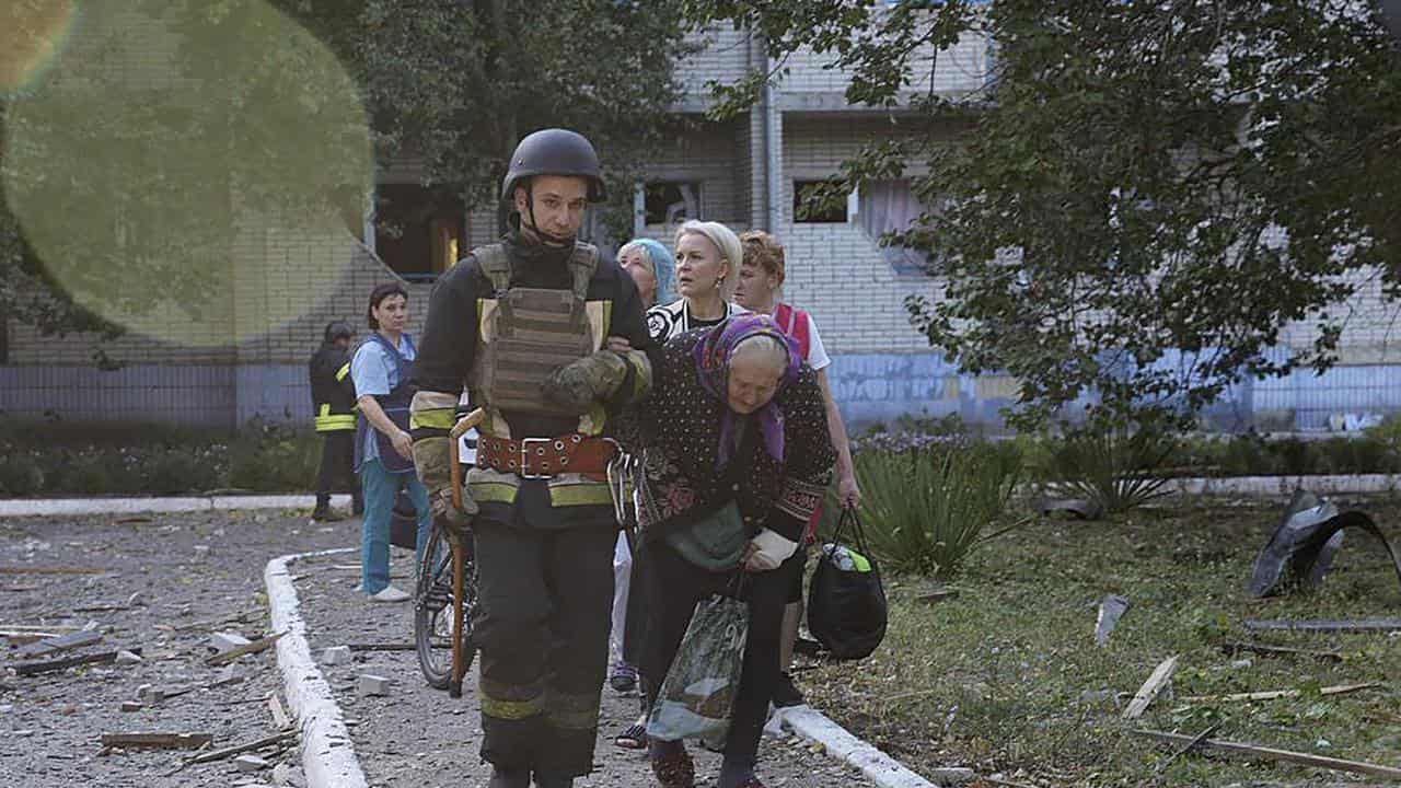 Elderly woman is assisted by emergency services