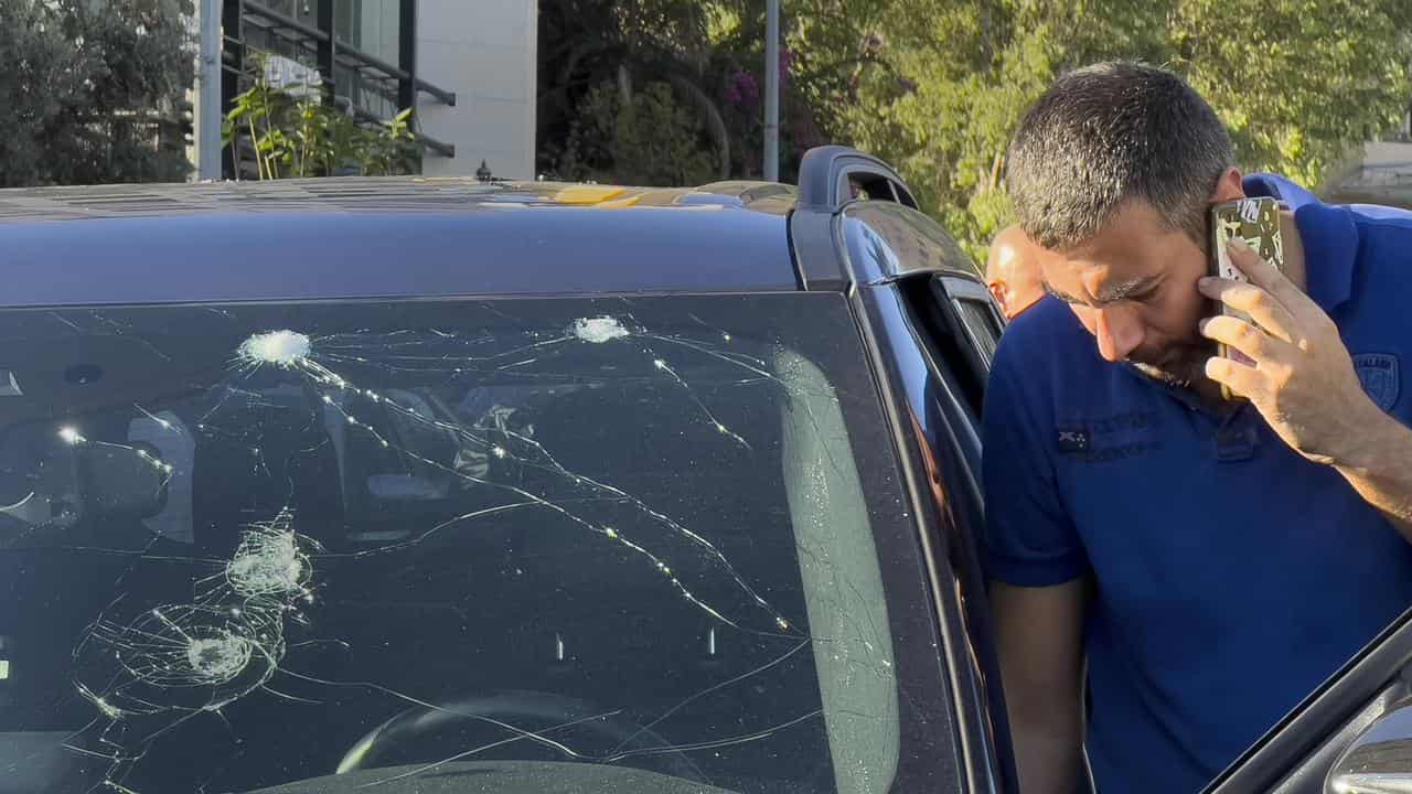 Police officer inspects a car in which a pager exploded in Lebanon