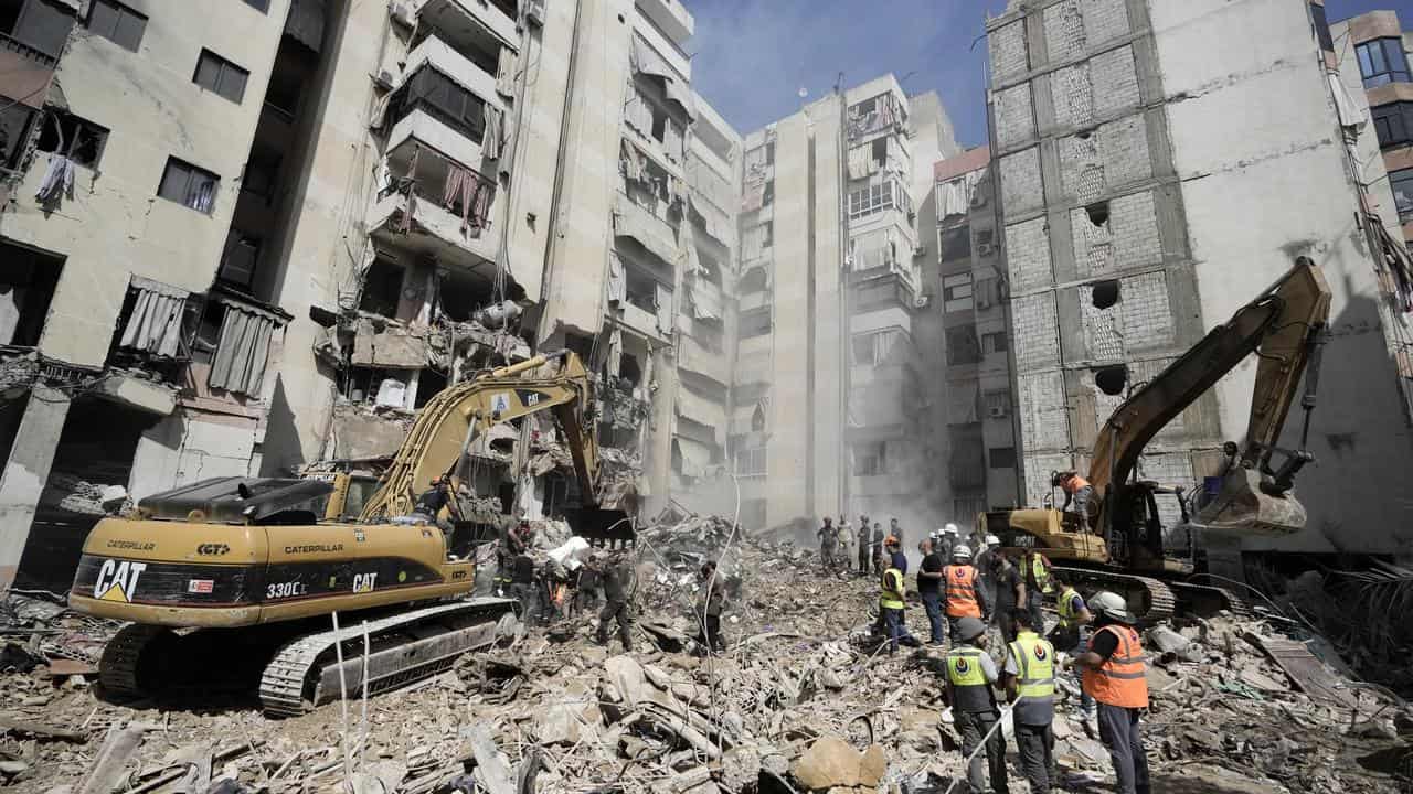 Emergency workers clear rubble after an Israeli strike in Beirut