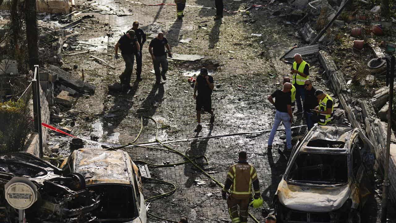 Security forces examine a site hit by a rocket in Kiryat Bialik