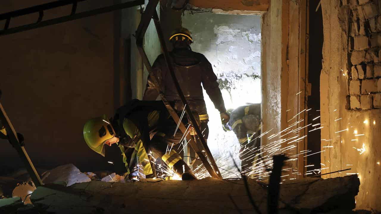 Emergency workers move rubble after a Russian strike on a building 