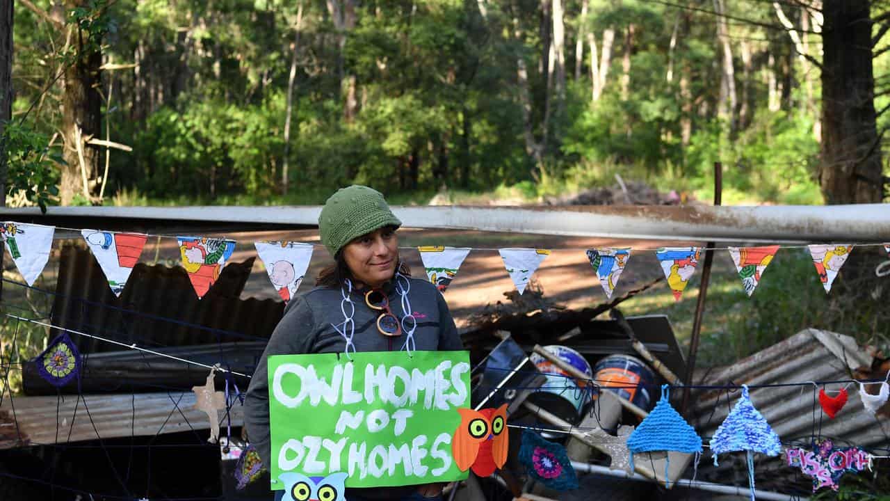 A local at a barricade blocking the entrance to bushland