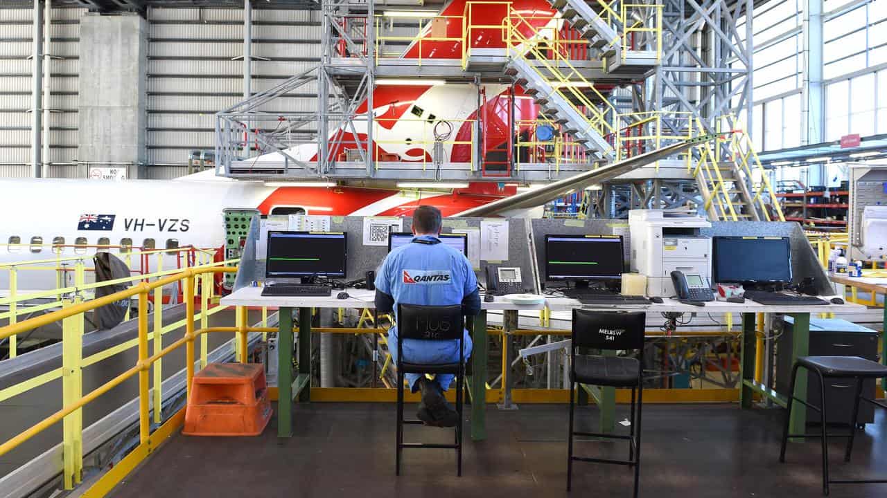 A Qantas employee seen as an aircraft receives maintenance