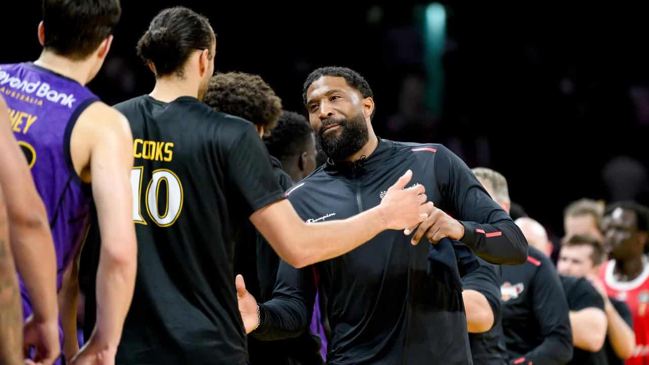 Justin Tatum shakes hands with Sydney Kings' Xavier Cooks.