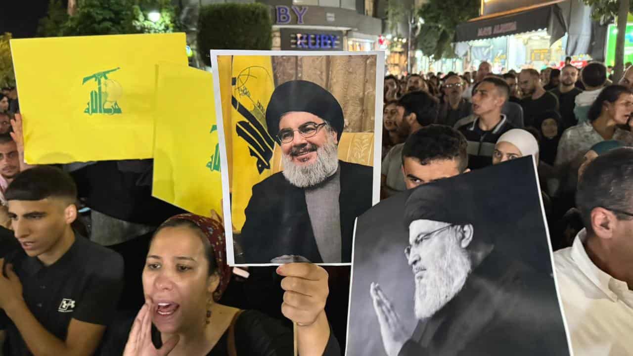 Protesters carry posters of Hassan Nasrallah in the West Bank