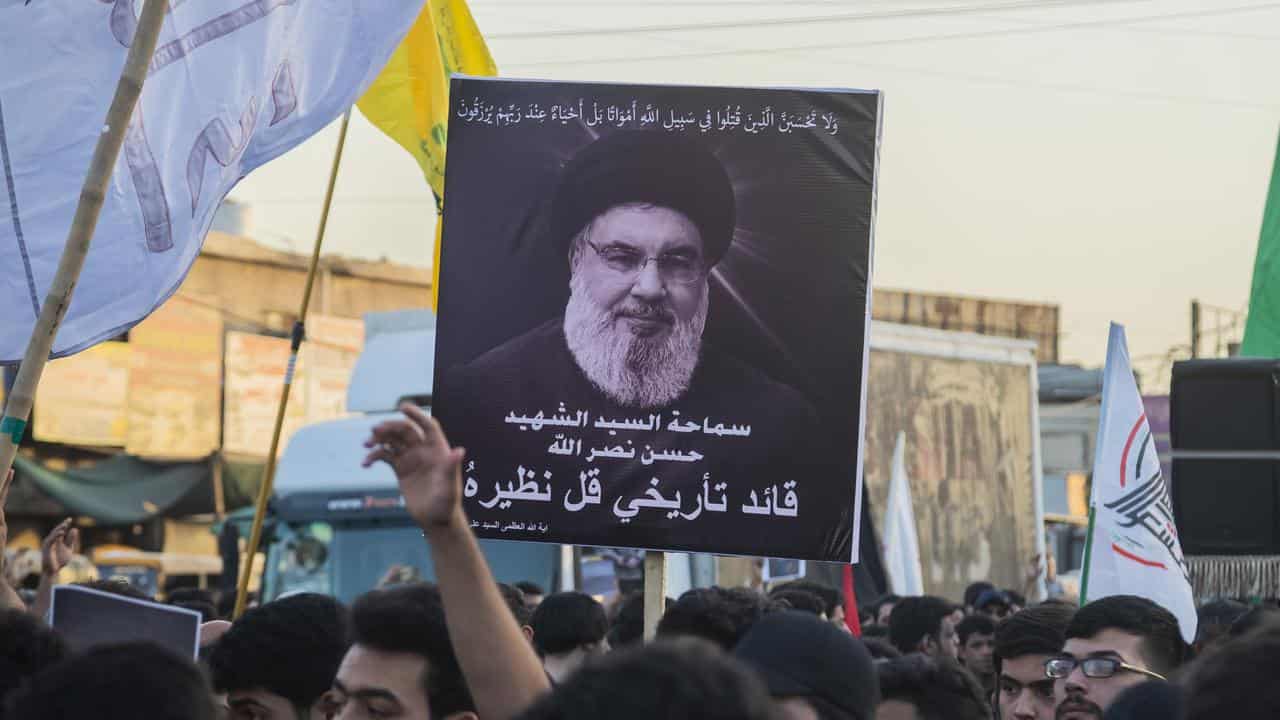 Iraqi Shii'tes hold a picture of Hezbollah leader Hassan Nasrallah