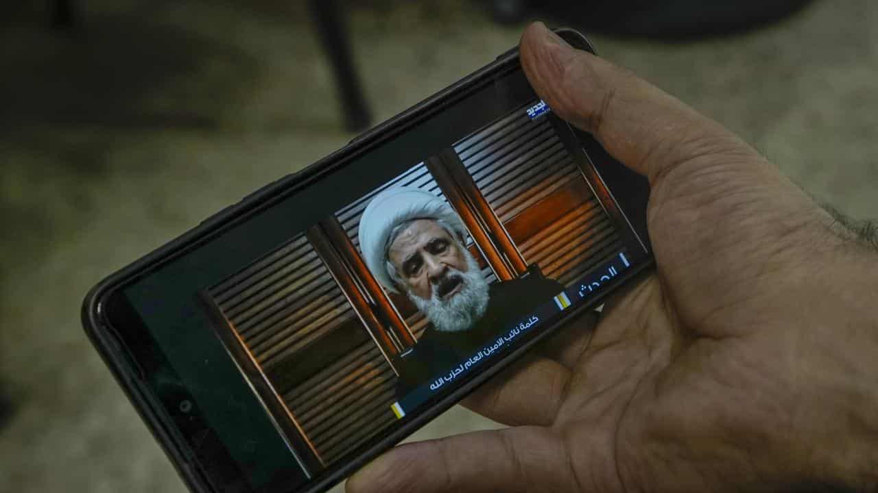 A man listens to a speech by Hezbollah deputy leader Naim Qassem