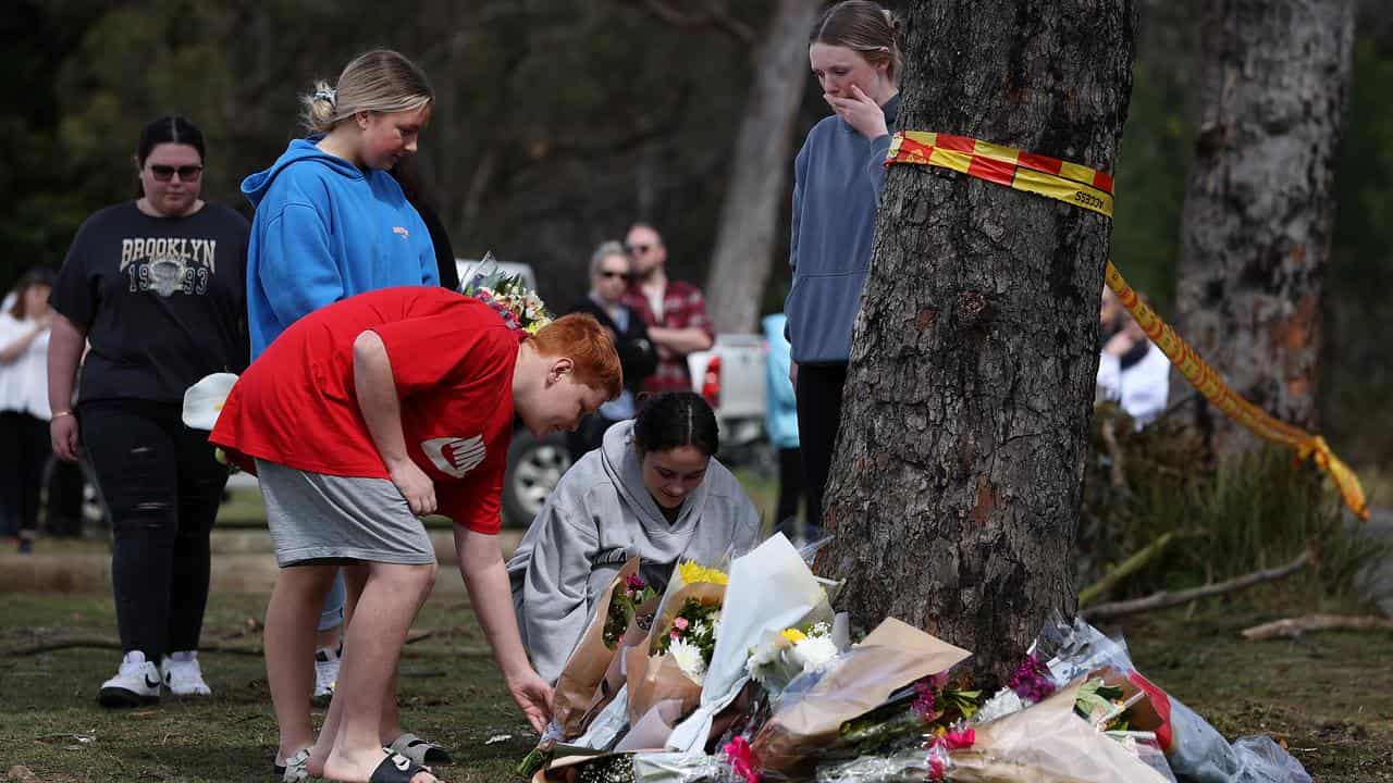 People leave flowers at the crash scene at Buxton, southwest of Sydney