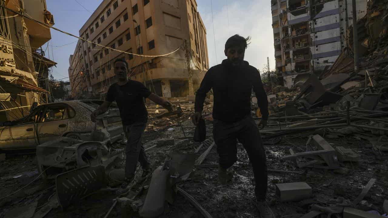 Residents run for cover following an Israeli strike in Dahiyeh, Beirut