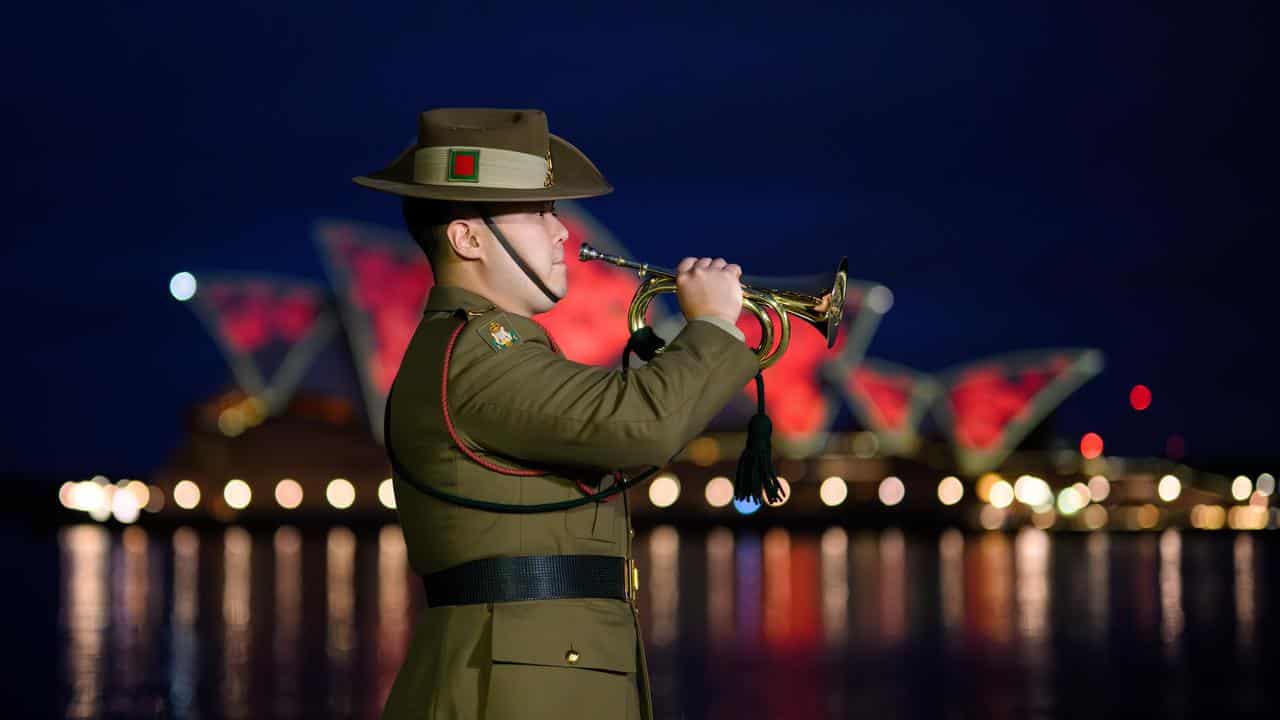 Army bugler performs near the Sydney Opera House at dawn.