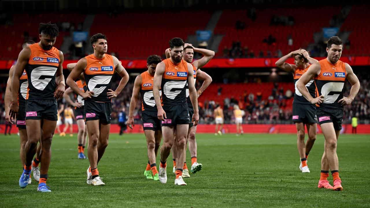 Toby Greene (right) leads the Giants off the field.