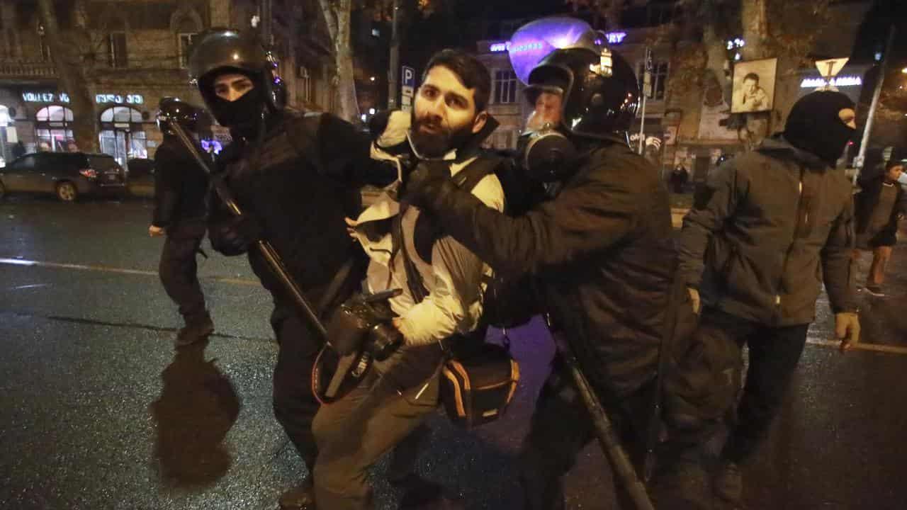 Police detain a journalist during protests in Tbilisi, Georgia