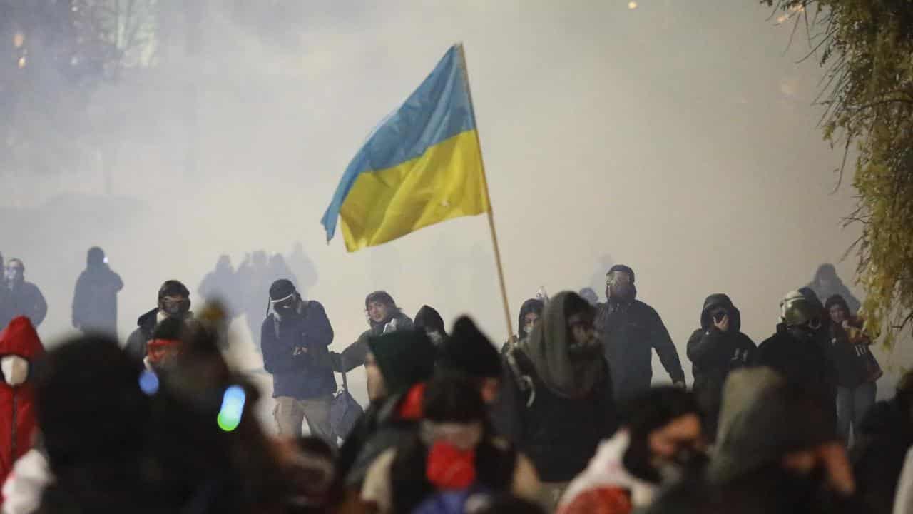 Demonstrators run away from a cloud of tear gas in Tibilisi, Georgia