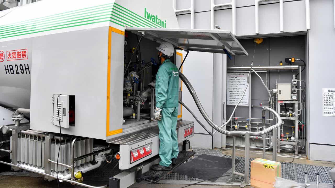 A employee pumps hydrogen into a refuelling truck