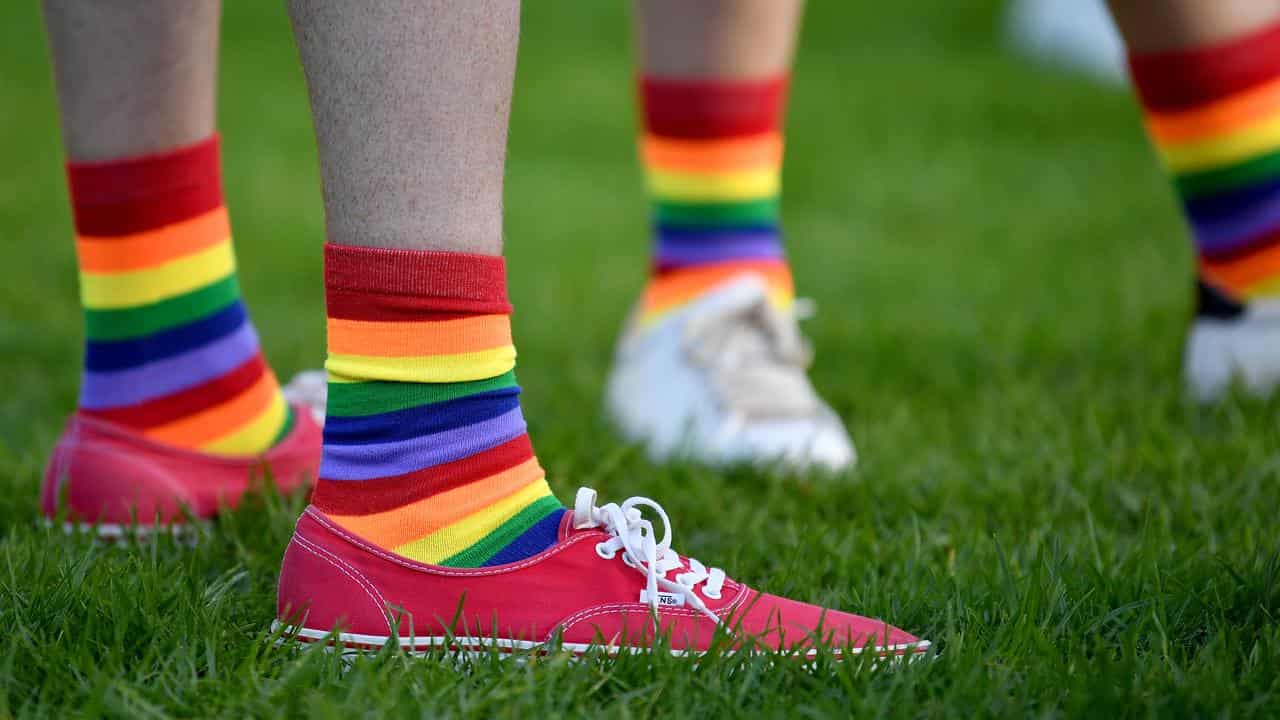 People dressed in the colours of the gay pride flag