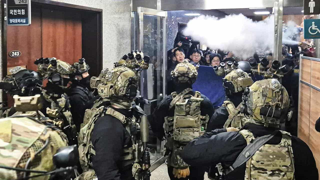 Staff spray fire extinguishers at soldiers in the National Assembly