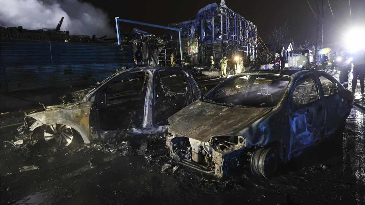 A car and a building destroyed by a Russian strike in Ukraine