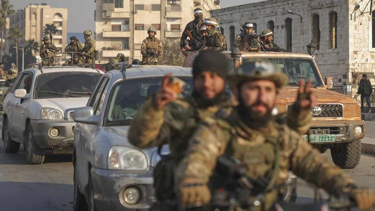 Syrian opposition fighters ride along the streets