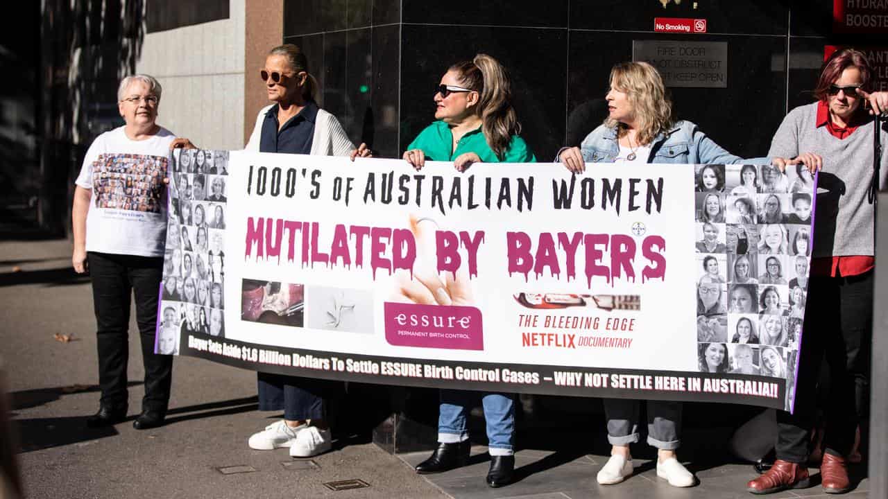 Women hold a banner outside court (file)