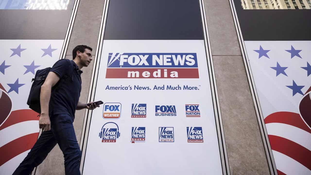 Person walks past Fox New headquarters in New York