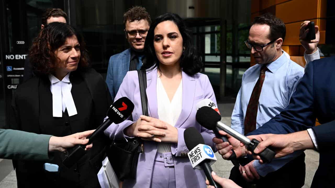 Independent MP Moira Deeming (centre) speaks to media 