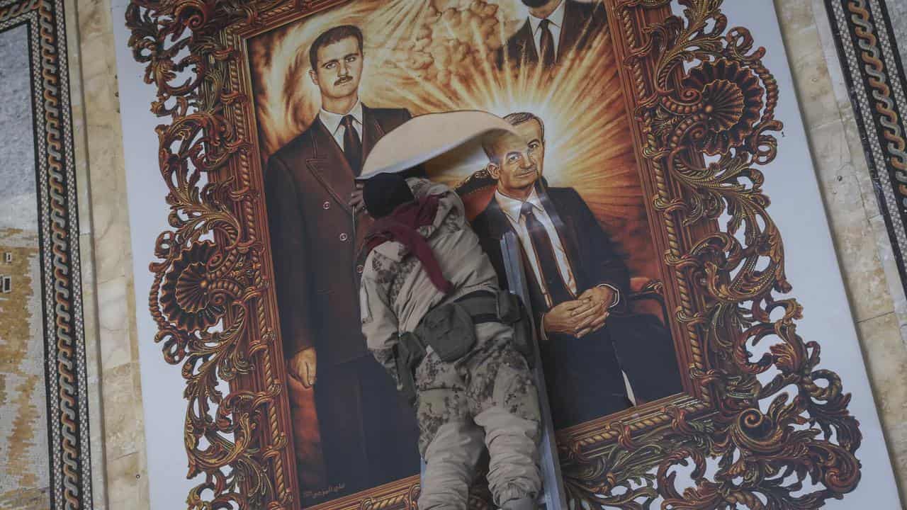 A painting of Bashar Assad is torn down