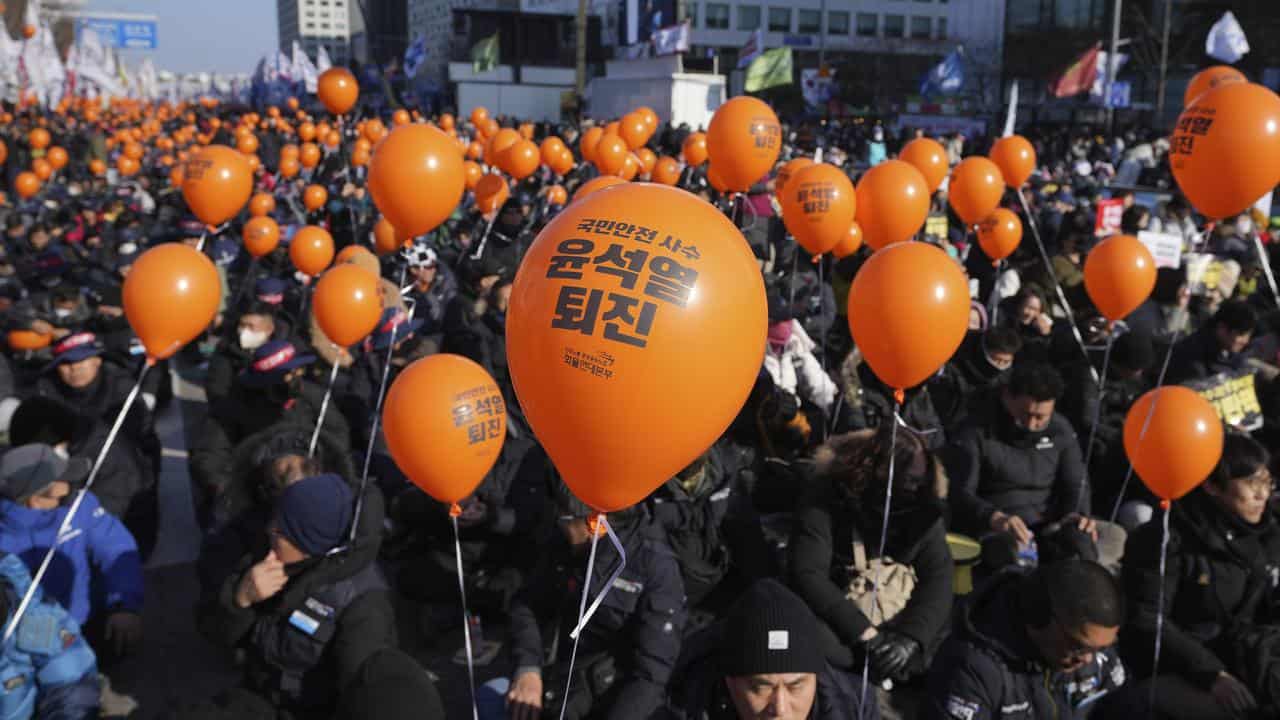 Protesters hold balloons at a rally calling for impeachment in Seoul.