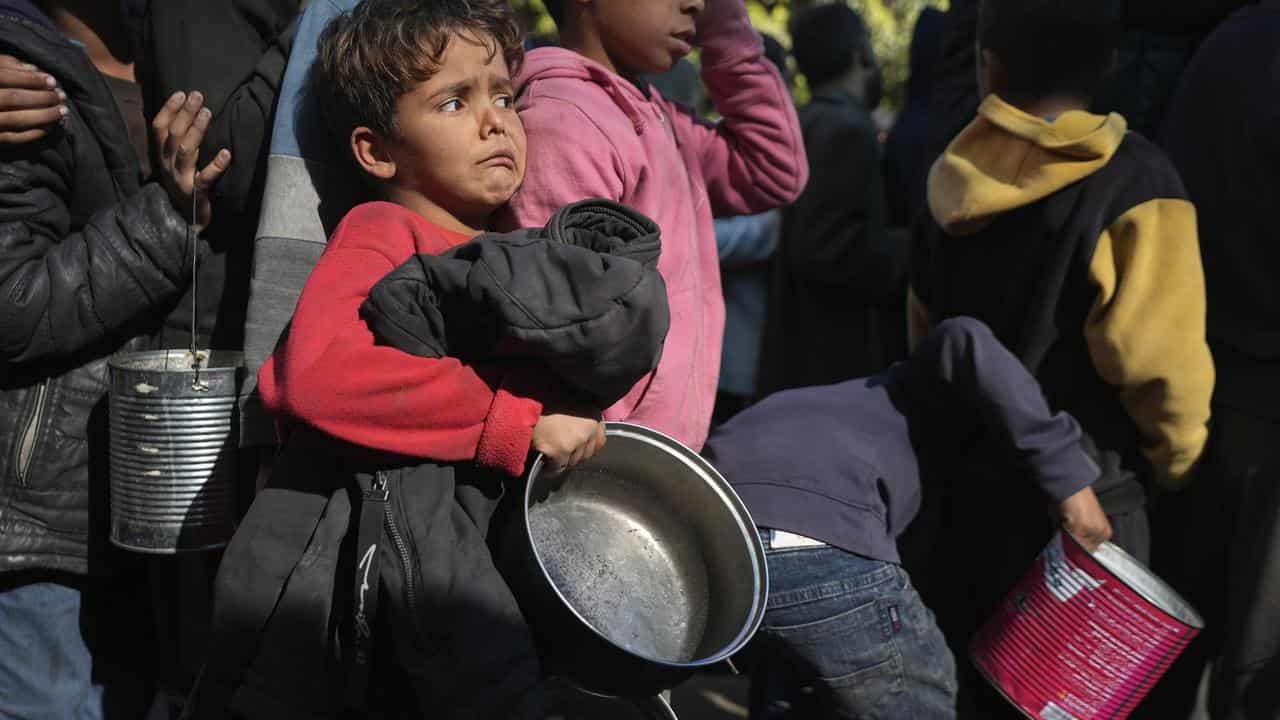 Palestinian children queue for food