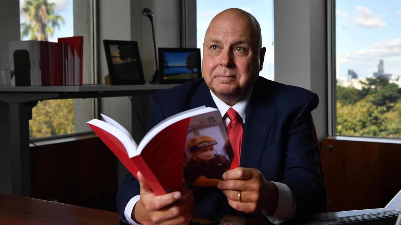 Victorian Treasurer Tim Pallas poses for a photo with budget papers