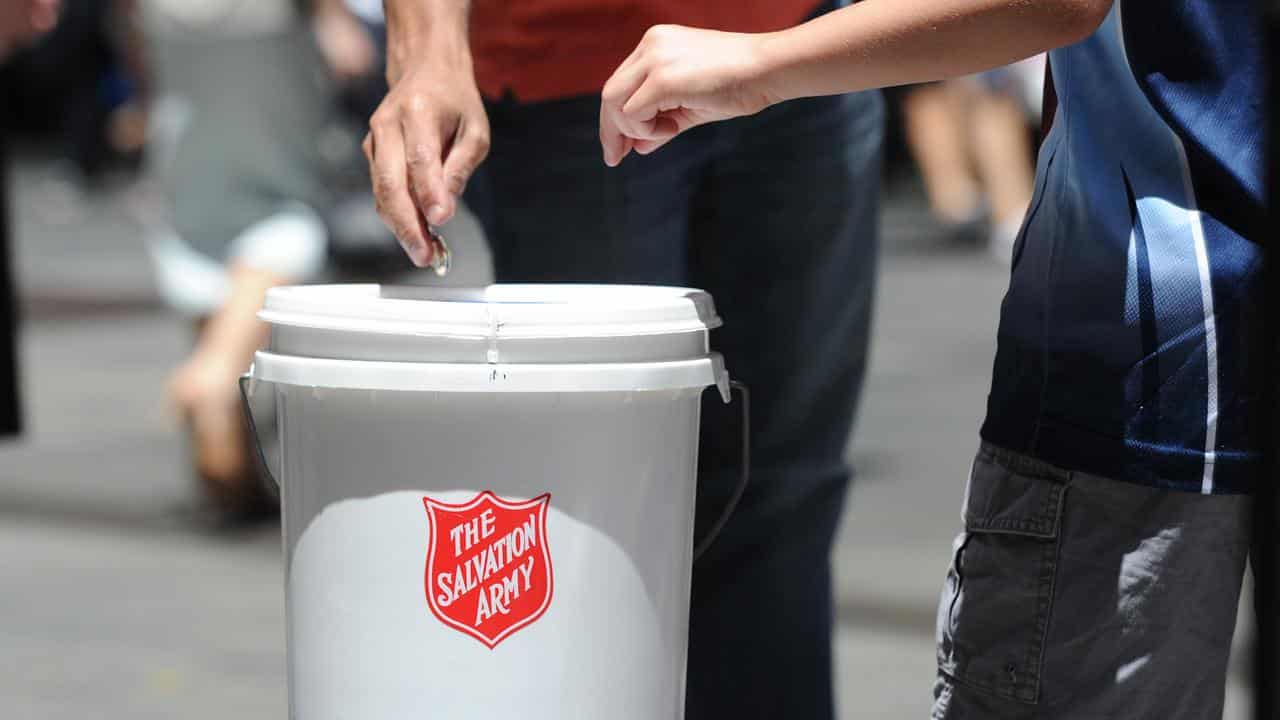 People donate coins to a Salvation Army charity bucket