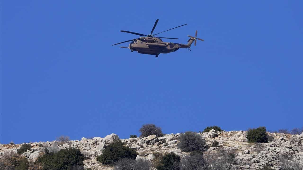 An Israeli Air Force Black Hawk helicopter flies over Mount Hermon