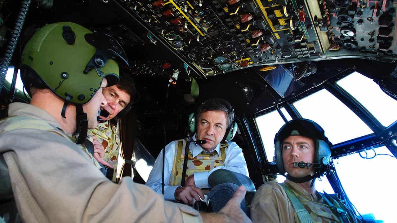 Defence Minister Robert Hill with pilots in Hercules aircraft cockpit