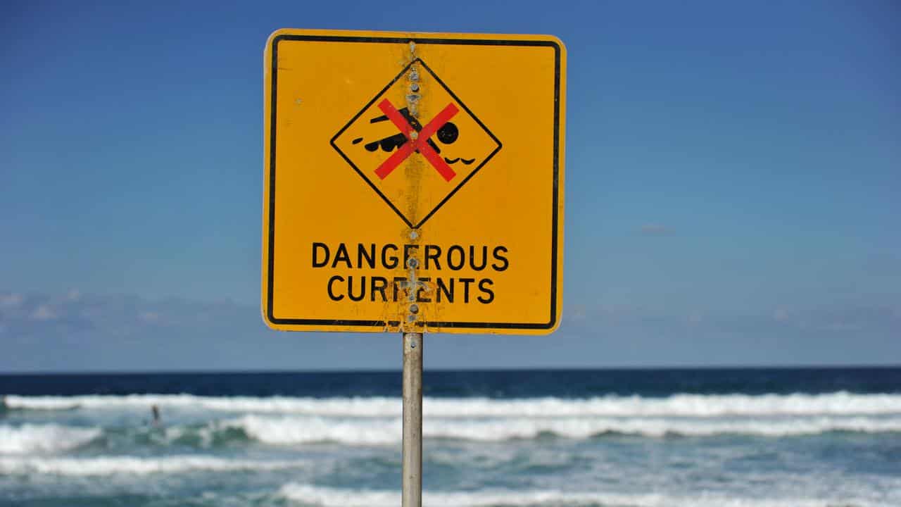 A sign warning of dangerous currents alerts swimmers